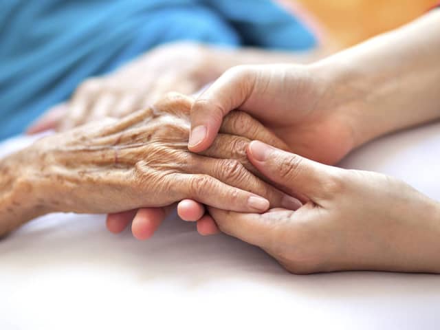 A generic photo of a woman holding a dementia sufferer's hands.