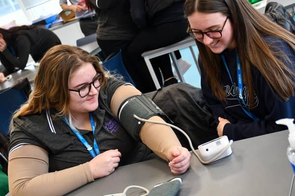 Students practising with a blood pressure cuff during the session.