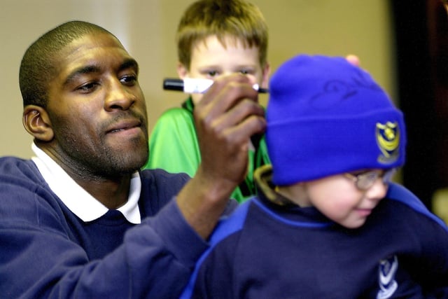 Darren Moore signs his autograph on the back of young fan's hat during a reserve game against Peterborough United in 2005