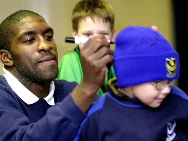 Darren Moore signs his autograph on the back of young fan's hat during a reserve game against Peterborough United in 2005