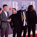 British singer and songwriter Sam Fender (third left) poses on the red carpet upon his arrival for the BRIT Awards 2022.