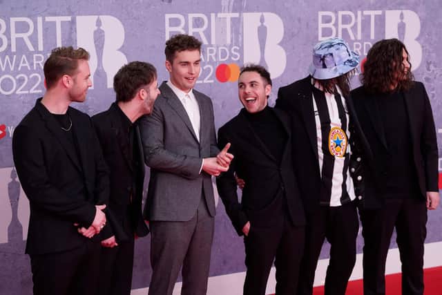 British singer and songwriter Sam Fender (third left) poses on the red carpet upon his arrival for the BRIT Awards 2022.