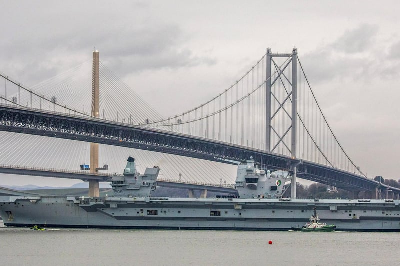 HMS Queen Elizabeth makes her way under the Forth Bridges as she prepares to dock at Rosyth dockyard for repairs, March 21 2024.