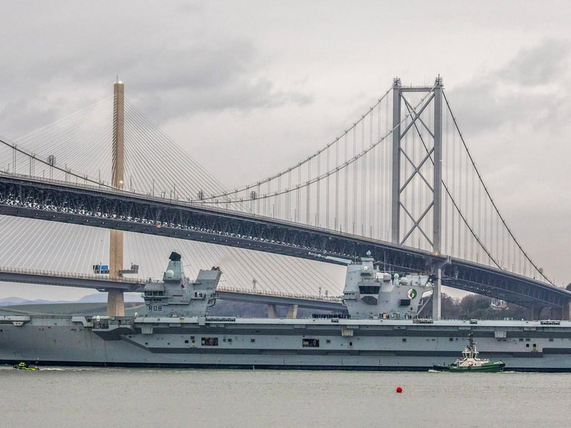 HMS Queen Elizabeth makes her way under the Forth Bridges as she prepares to dock at Rosyth dockyard for repairs, March 21 2024.