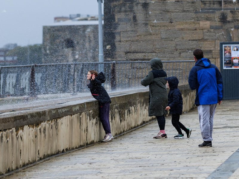 The stormy sea at high tide crashed waves onto footpaths as passer-by's did their best to get out the way (or not, in this case)