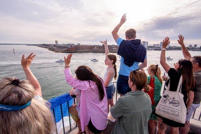Crowds watch the boat parade for Sea Angling Classic 2022 from Round Tower, Old Portsmouth