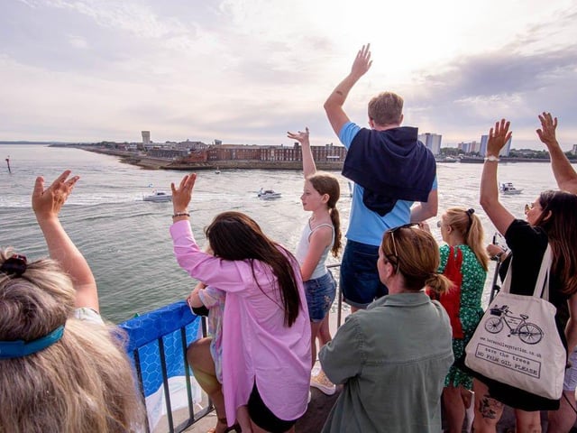 Crowds watch the boat parade for Sea Angling Classic 2022 from Round Tower, Old Portsmouth