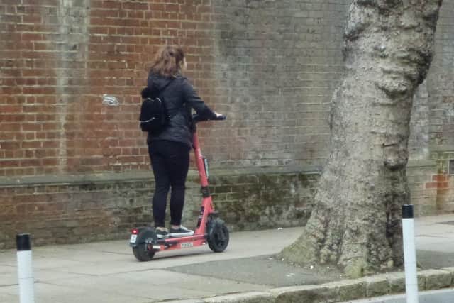 A Voi scooter being ridden on the pavement in Ordnance Road, Portsea