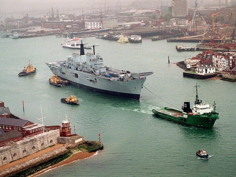 HMS Ark Royal being towed by tugs through the narrows, as she leaves Portsmouth Naval Base for Rosyth in 1999. Picture: Mike Scaddan 992149-2