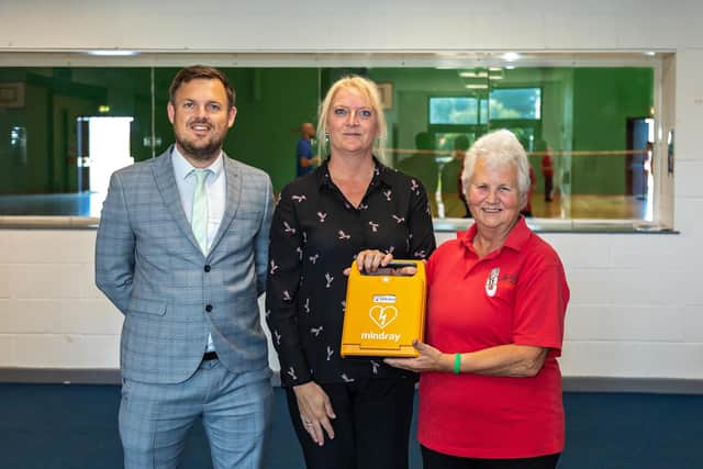 Bay House School assistant headteacher Tom Morgan and welfare officer Sarah Cornish receive the defibrillator from Elizabeth Humphries Picture: Mike Cooter (240921)