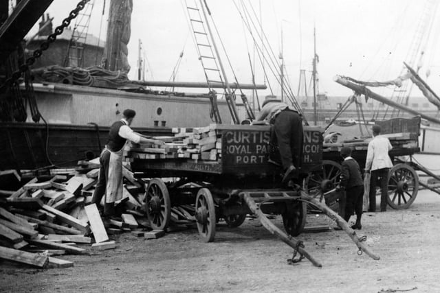 circa 1900:  Loading timber onto a wagon at Portsmouth Docks.  (Photo by F J Mortimer/Hulton Archive/Getty Images)