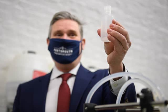 Labour leader Keir Starmer bottles and labels a bottle of hand sanitiser as he visits the Portsmouth Gin Distillery during a visit to promote business in the city in December. (Photo by Leon Neal/Getty Images)
