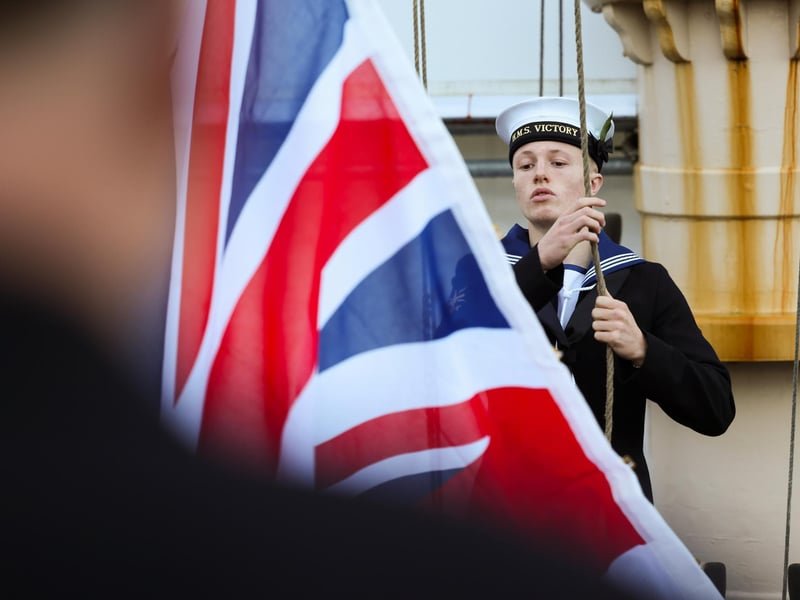 Pictured: Morning colours being conducted before the Trafalgar Day ceremony on HMS Victory.