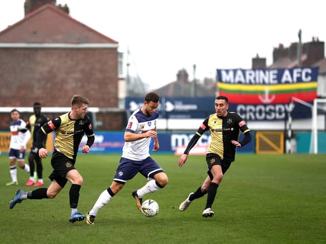 Josh Taylor pictured with Marine duo James Joyce and Josh Hmami during the FA Cup second round tie at the end of November. Hawks lost to a late goal and Marine are now looking forward to welcoming Tottenham. Photo by Jan Kruger/Getty Images.