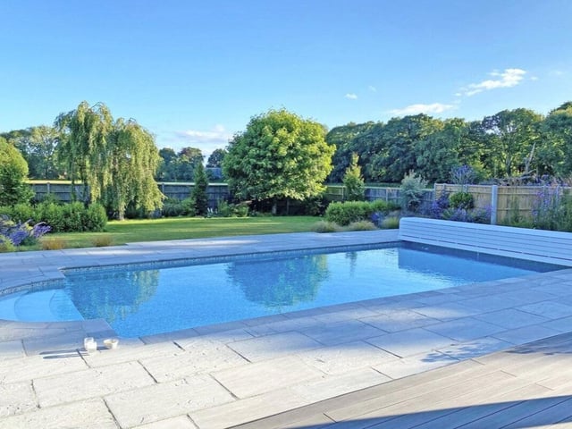 The listing says: "Beautifully presented detached family home with superb kitchen/dining/family room, four bedrooms, three en suite shower rooms and family bathroom, detached two bedroom self contained annexe, set in a quiet country lane with south facing gardens, heated outdoor pool and views over neighbouring fields."