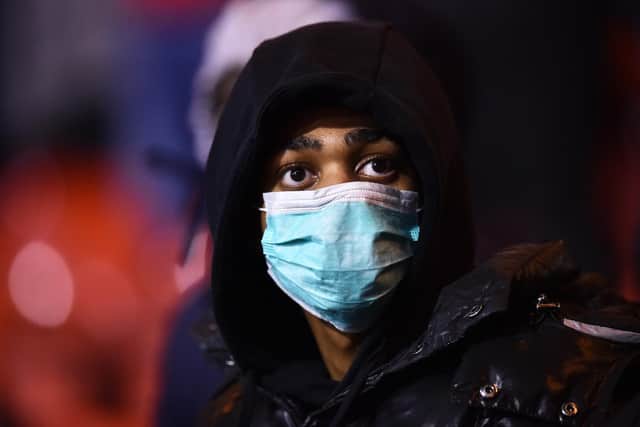 A fan at a football match wears a face mask as protection from Coronavirus. Picture: Nathan Stirk/Getty Images