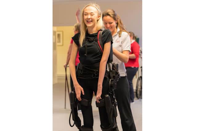Jess walking in an exoskeleton.
