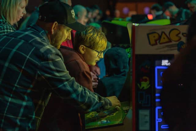 Passing on old skills in the retro gaming area provided by Game Over. Picture: Mike Cooter (040223)