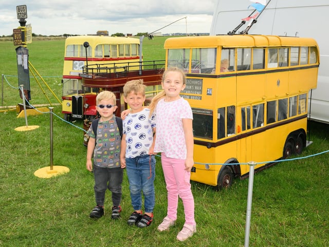 Pictured is: Children pose next to electric scooters disguised as buses.
Picture: Keith Woodland