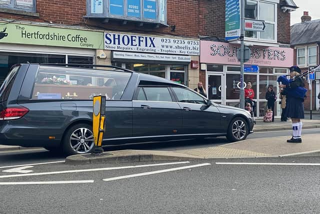 The funeral cortege of Doreen Colwell, 85, passes through High Street, Cosham, as musician Caroline Henton, 57, plays the bagpipes