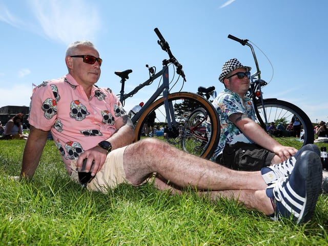 Father and son, Darrell and Max Huggins, enjoy the music on show at Castle Field, Southsea Picture: Chris  Moorhouse (250524-49)