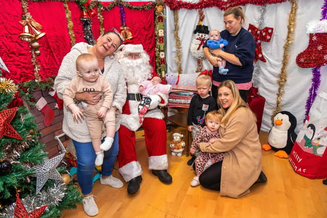 Samantha Mills with Carter Lowden (one) and Haisely Lowden (five weeks old) held by Santa (Mike Jerome), Arthur Shires (two) and Arna Shires (one) with Scarlett Turner (33), and Natasha Duquemin (35) holding Harrison (four months). Picture: Mike Cooter (261121)
