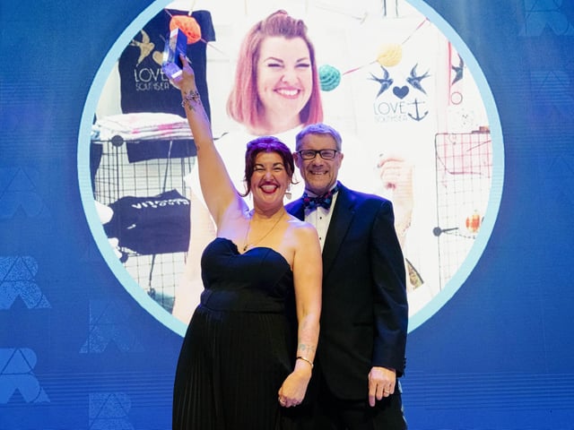 Lulu Whitmore celebrates on stage with Mark Waldron, editor in chief for National World.   Picture: Keith Woodland (270321-334)