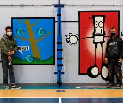 Artists My Dog Sighs (right) and Fark with the new mural.