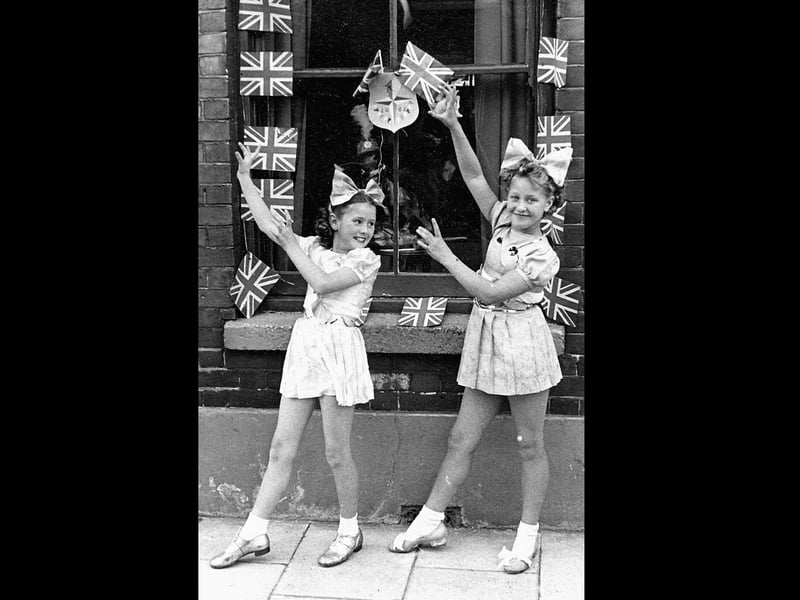 Festival of Britain street tea outside 14, Moorland Road Buckland Portsmouth. Kay Britno 9yrs on left & friend from Madame Selwood's dance troop outside her grandparents house entertaining the neighbours at a Festival of Britain street party in 1951