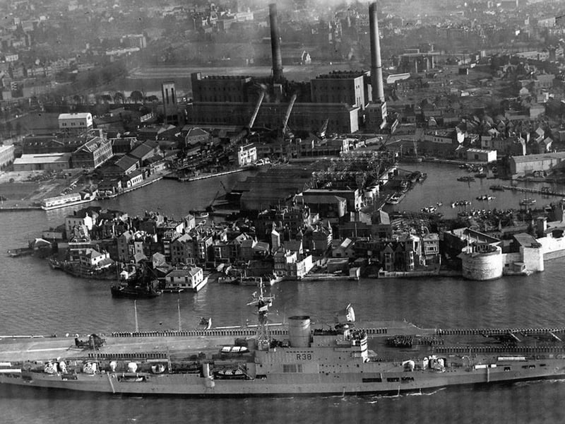 HMS Victorious leaves Portsmouth Harbour some time after 1958 as she has the angled flight deck that was fitted between 1950 and 1958.