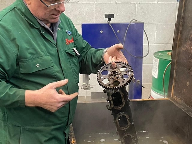 National Motor Museum Senior Engineer Ian Stanfield soaks camshaft glued by oil