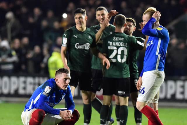 Pompey players Ronan Curtis and Connor Ogilive look dejected as Plymouth celebrate their win against the Blues on Tuesday night