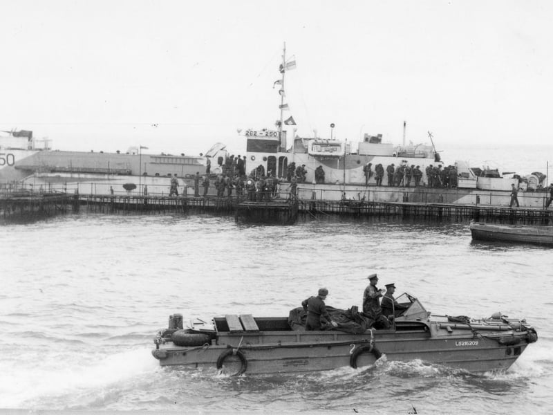 The LCI(L) or Landing Craft, Infantry (Large) landing craft in the background is at a temporary pier alongside South Parade Pier, put up to speed up the loading of troops heading for Normandy, for D-Day and after. The DUKW amphibious vehicle in the foreground was probably used by the troops organising the loading process, and helped load some equipment onto the landing craft.