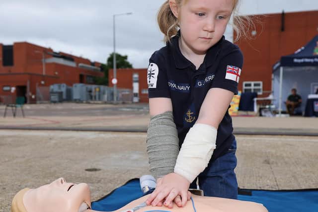 Stayin' alive - a girl turns her hand to some CPR during the HMS Spey families' day. Photo: LPhot Lee Blease