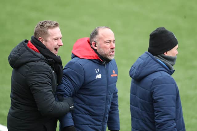 Fleet's head of performance Lee Taylor, middle, is held back by boss Dennis Kutrieb as he shouts at Hawks manager Paul Doswell. Photo by Dave Haines