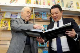 Amateur photographer Pietro Rocchiccioli (74) from Hayling Island, has created a book documenting Hayling Island during the Covid-19 pandemic first lockdown. Pictured is: (left) Pietro Rocchiccioli showing his book to Alan Mak MP for Havant who bought a copy.Picture: Sarah Standing (040322-187)