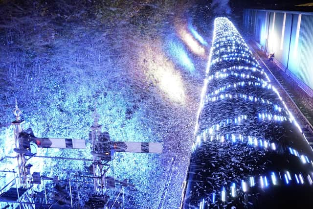 The BR Standard Class no. 70167 passes through fake snow as it leaves Ropley station as it pulls a Steam Illuminations train, a light show on and in a steam train, consisting of thousands of fully controllable colour mixing LED lights, on the Watercress Line in Hampshire, which forms part of their Christmas programme of events. Picture date: Friday November 12, 2021. PA Photo. Photo credit should read: Andrew Matthews/PA Wire
