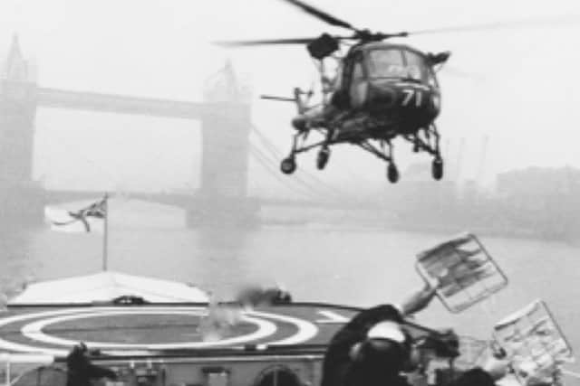 The flight deck control officer brings in a Wasp to land in sight of Tower Bridge. Picture: Mike Mcbride collection