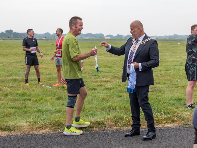 Councillor Fred Birkett (Mayor of Fareham) presents a medal to a participant of the Run The Runway event.
Picture: Mike Cooter