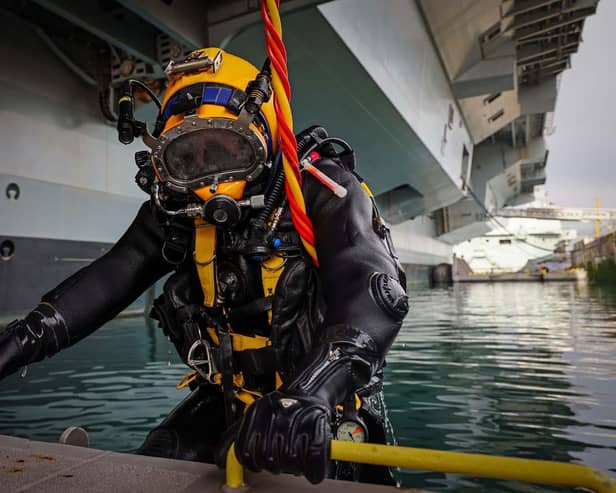 Royal Navy Divers are carrying out work on the hull of HMS Prince of Wales whilst the ship is alonside in HMNB Portsmouth, Hampshire on 10th February 2022.