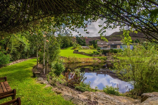 The landscaped grounds surround the entire home and comprise manicured lawns, flower beds and walls of trees, and offer moorland views for miles around.