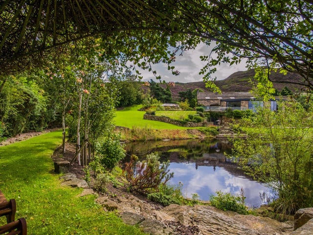 The landscaped grounds surround the entire home and comprise manicured lawns, flower beds and walls of trees, and offer moorland views for miles around.