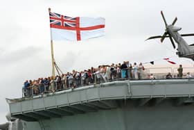 IFOS 3rd July 2005. Enjoying the view! Hundreds of members of the public on the aft of the flight deck on HMS Illustrious watching one of the many public displays going on in the water below in the Navy Base. Picture: Malcolm Wells 053125-130