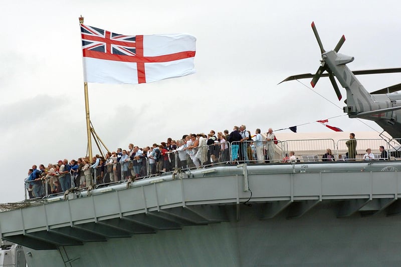 IFOS 3rd July 2005. Enjoying the view! Hundreds of members of the public on the aft of the flight deck on HMS Illustrious watching one of the many public displays going on in the water below in the Navy Base. Picture: Malcolm Wells 053125-130