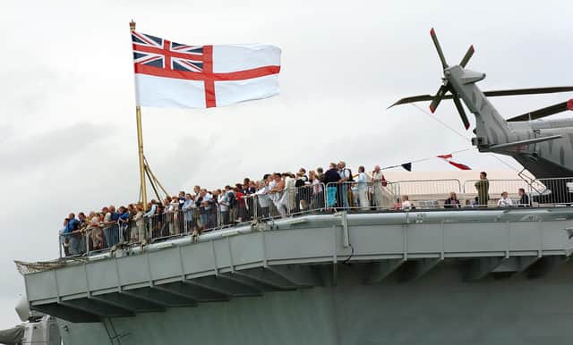 IFOS 3rd July 2005. Enjoying the view! Hundreds of members of the public on the aft of the flight deck on HMS Illustrious watching one of the many public displays going on in the water below in the Navy Base. Picture: Malcolm Wells 053125-130