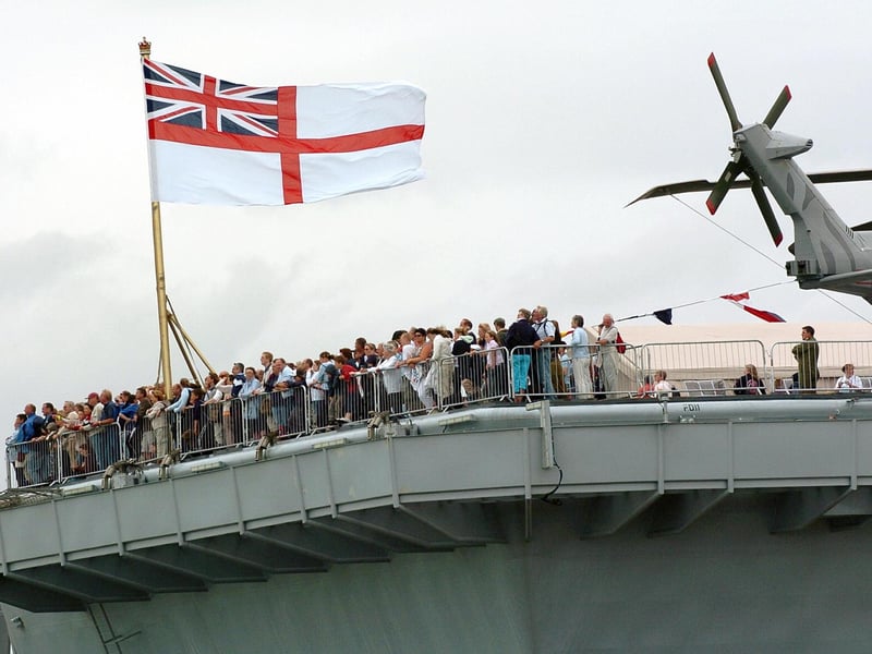IFOS 3rd July 2005. Enjoying the view! Hundreds of members of the public on the aft of the flight deck on HMS Illustrious watching one of the many public displays going on in the water below in the Navy Base. Picture: Malcolm Wells 053125-130