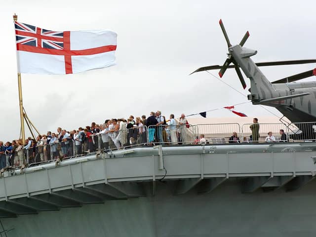 IFOS 3rd July 2005. Enjoying the view! Hundreds of members of the public on the aft of the flight deck on HMS Illustrious watching one of the many public displays going on in the water below in the Navy Base. Picture: Malcolm Wells 053125-130