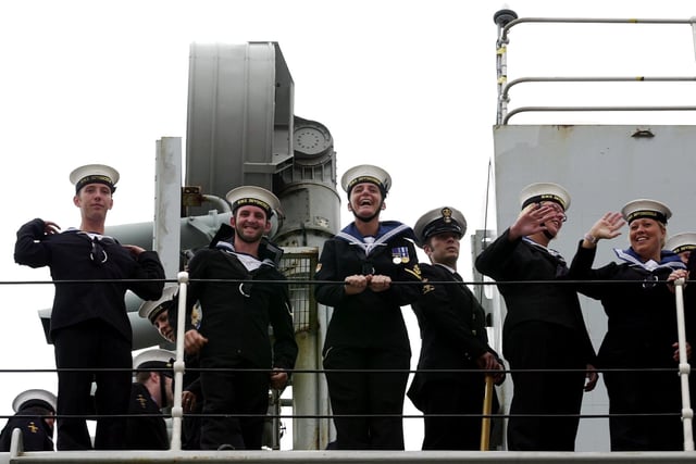 Sailors wave at loved ones waiting for them as HMS Invincible comes into Portsmouth Harbour after major exercises off the eastern United States and a flag flying visit to New York. 16th July 2004. Picture: Matt Scott-Joynt (043591-27)
