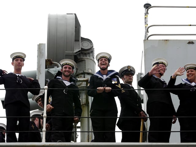 Sailors wave at loved ones waiting for them as HMS Invincible comes into Portsmouth Harbour after major exercises off the eastern United States and a flag flying visit to New York. 16th July 2004. Picture: Matt Scott-Joynt (043591-27)