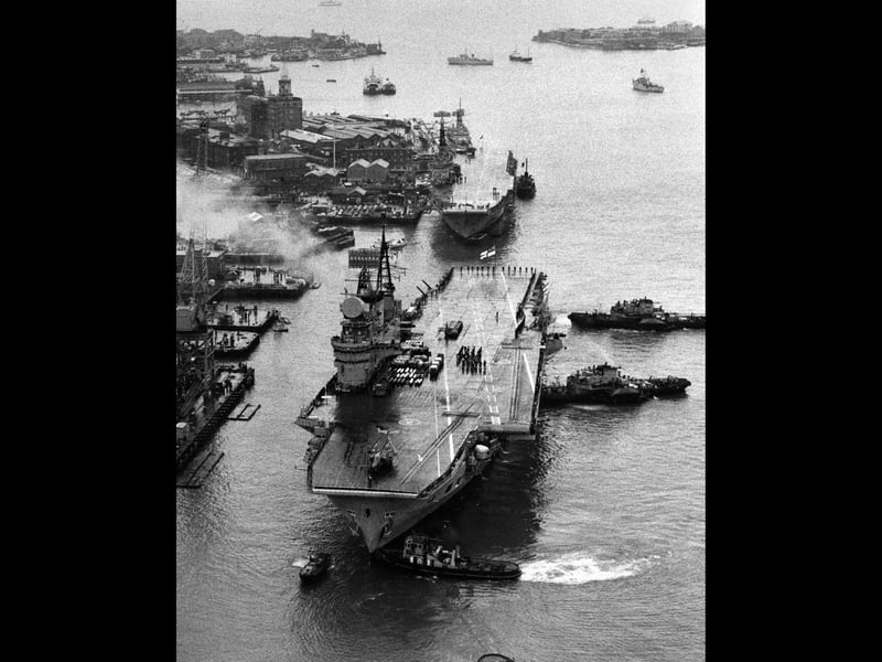 Aerial view the flight deck of the Royal Navy Audacious-class fleet aircraft carrier HMS Eagle as tugboats ease her towards the dockside of Portsmouth harbour to be paid off and scrapped on 26 January 1972 at Portsmouth, United Kingdom. The commando carrier HMS Albion is docked behind HMS Eagle. (Photo by Central Press/Hulton Archive/Getty Images).